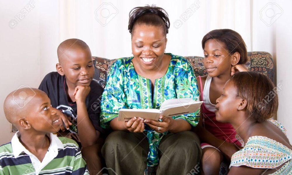 4255586 a happy african mother reading a book to her 4 children in living room