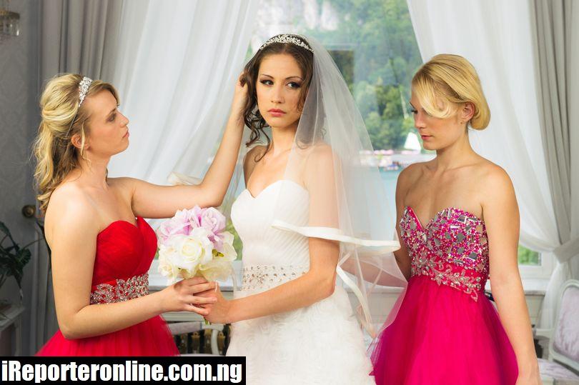 0 Bridesmaides elping a nervous bride to get readyjpgas betra