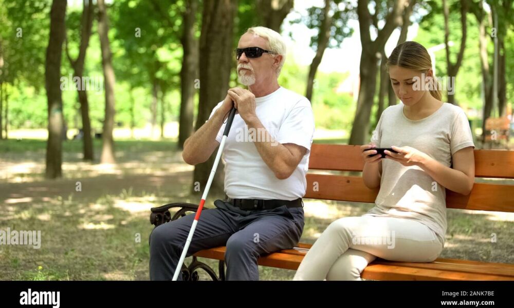 blind man sitting on bench healthy lady using phone instead enjoying nature 2ANK7BE