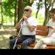 blind man sitting on bench healthy lady using phone instead enjoying nature 2ANK7BE