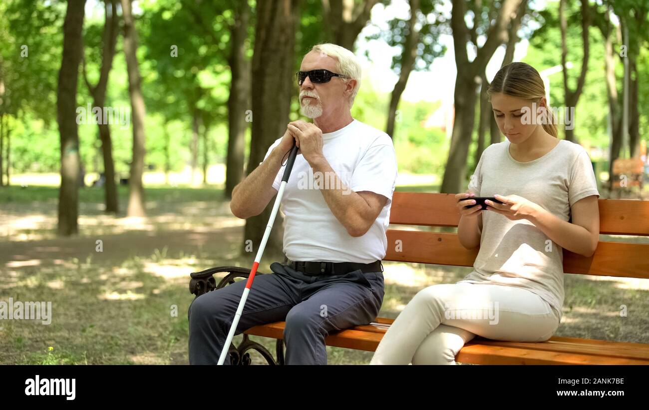 blind man sitting on bench healthy lady using phone instead enjoying nature 2ANK7BE